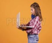 Get 100&#39;s of FREE Video Templates, Music, Footage and More at Motion Array: http://bit.ly/2SITwWM nnnGet this here: https://motionarray.com/stock-video/young-girl-with-laptop-in-hands-152518nnThis stock footage shows an young girl with laptop in hands over an yellow orange background. She wears a pair of blue wireless headphones and at one point it`s very surprised of what she sees on the screen. This is a perfect fit for tv shows, web adds, vlogs or other projects related to young girl with lap